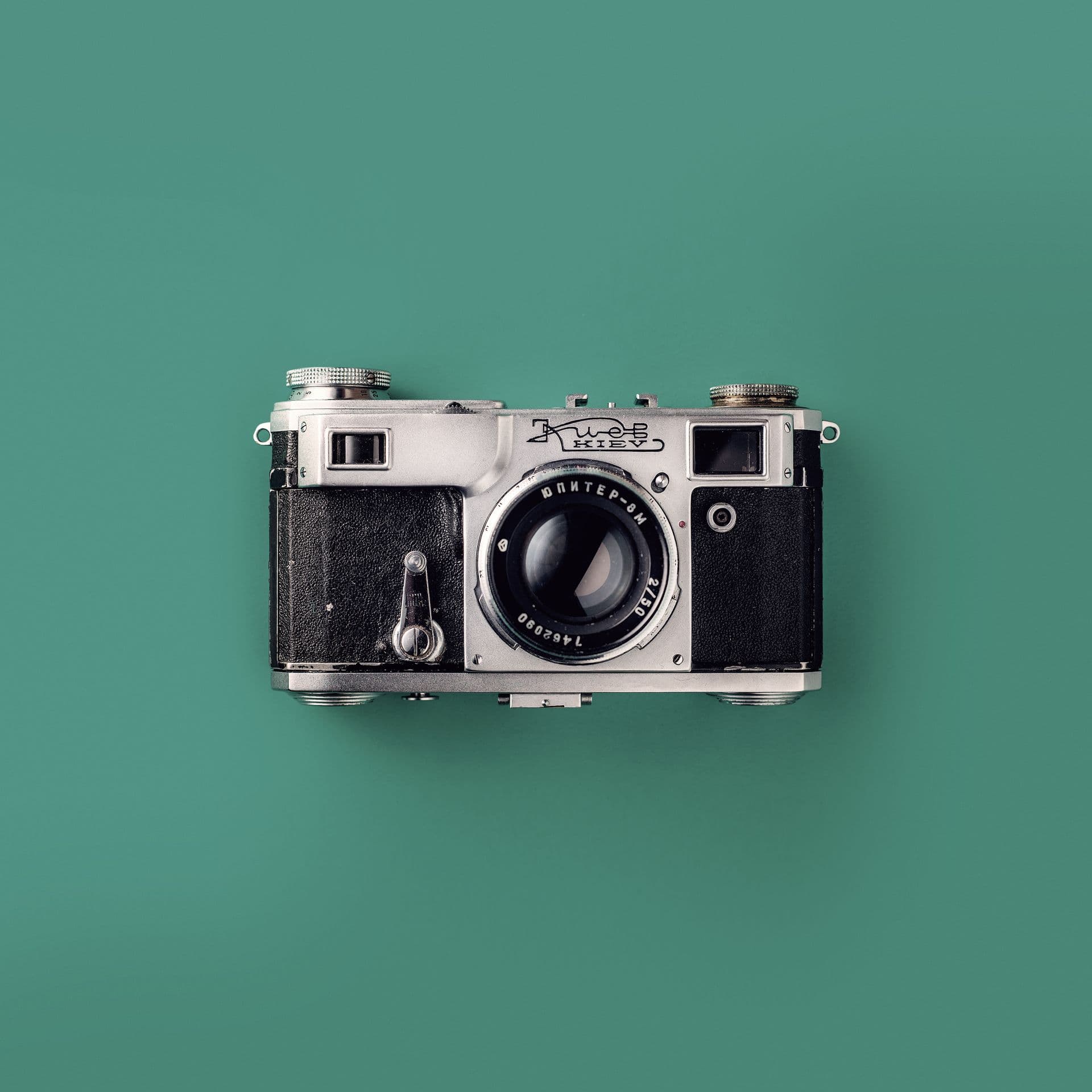 Vintage rangefinder camera on a teal background