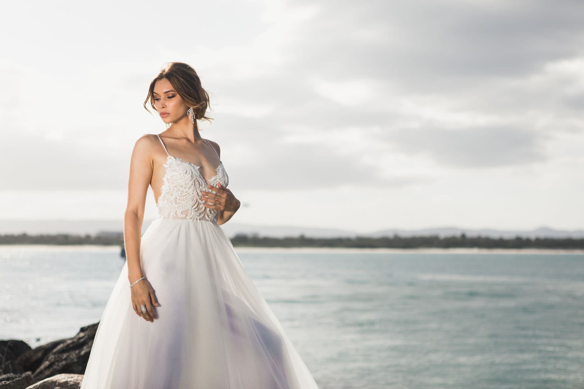 Bride in white walking along the sea