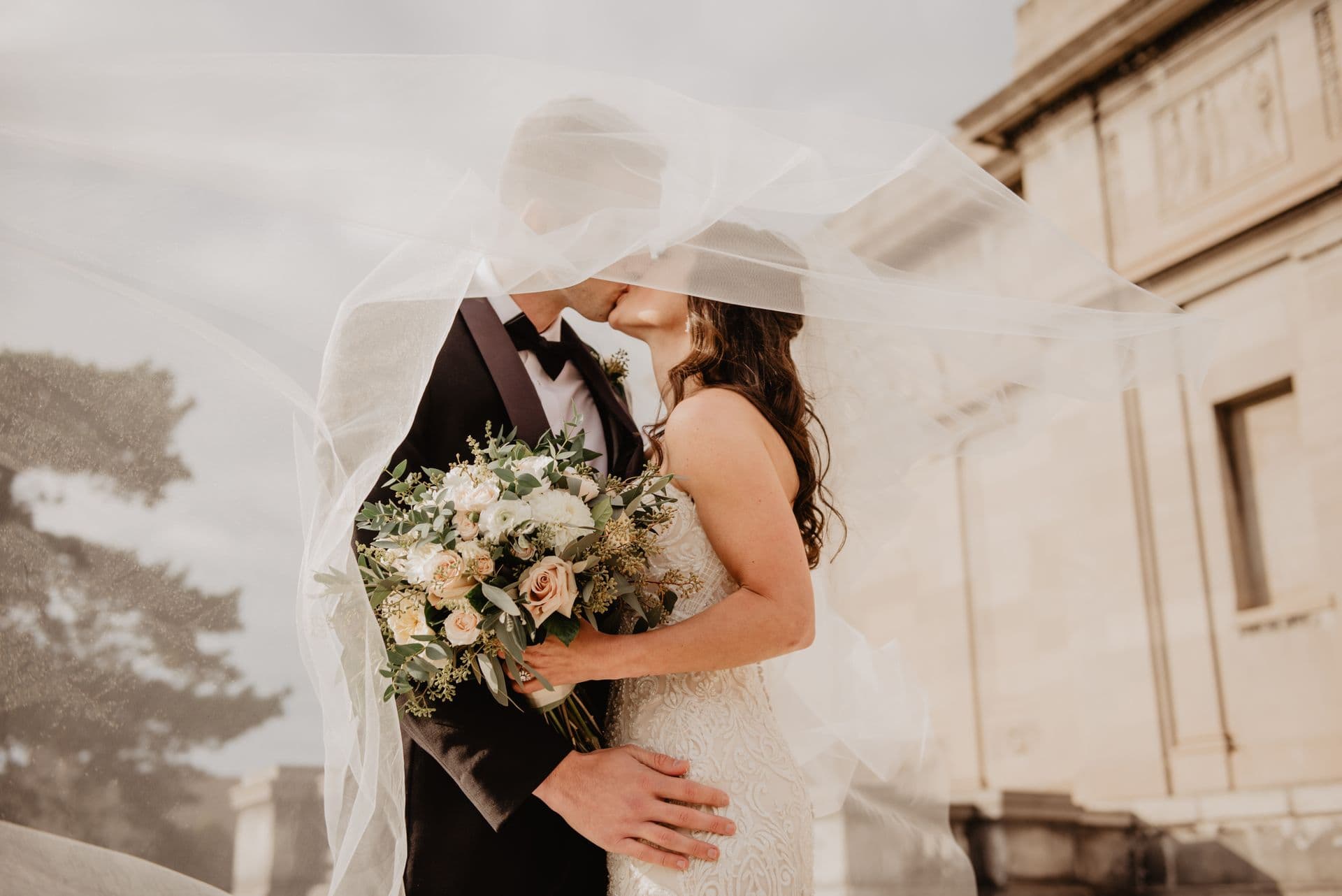 Couple embracing with a bouquet, warm tones