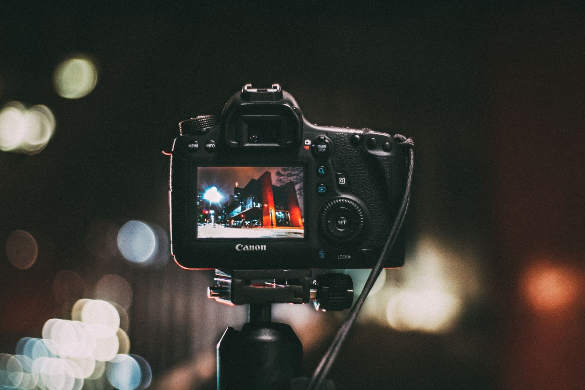 DSLR on a tripod showing the rear LCD in low light