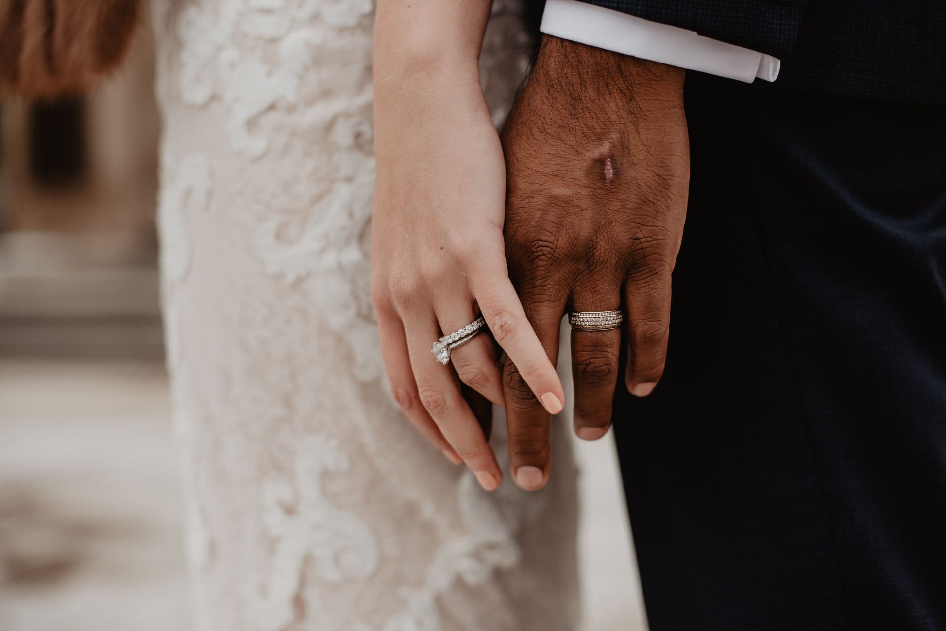 Couple’s hands with wedding rings, moody light