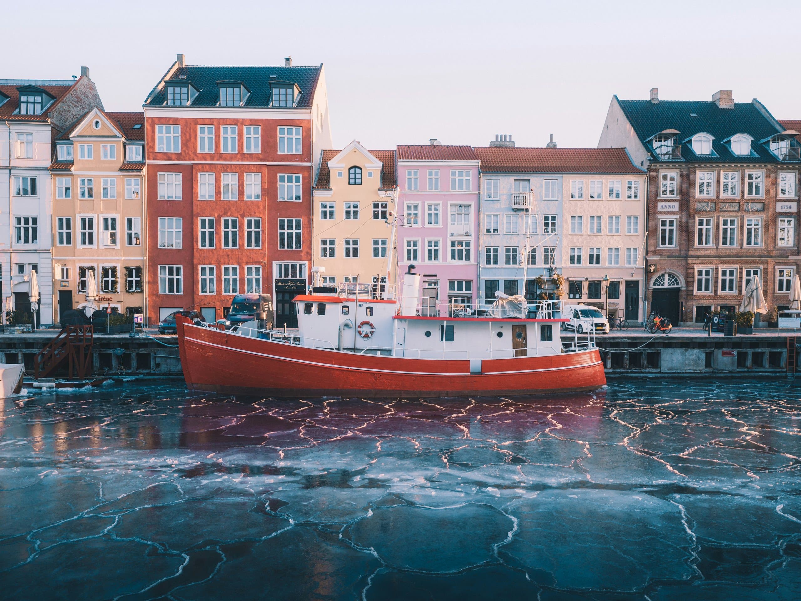 Red boat on a frozen canal before the colourful Nyhavn houses, Copenhagen